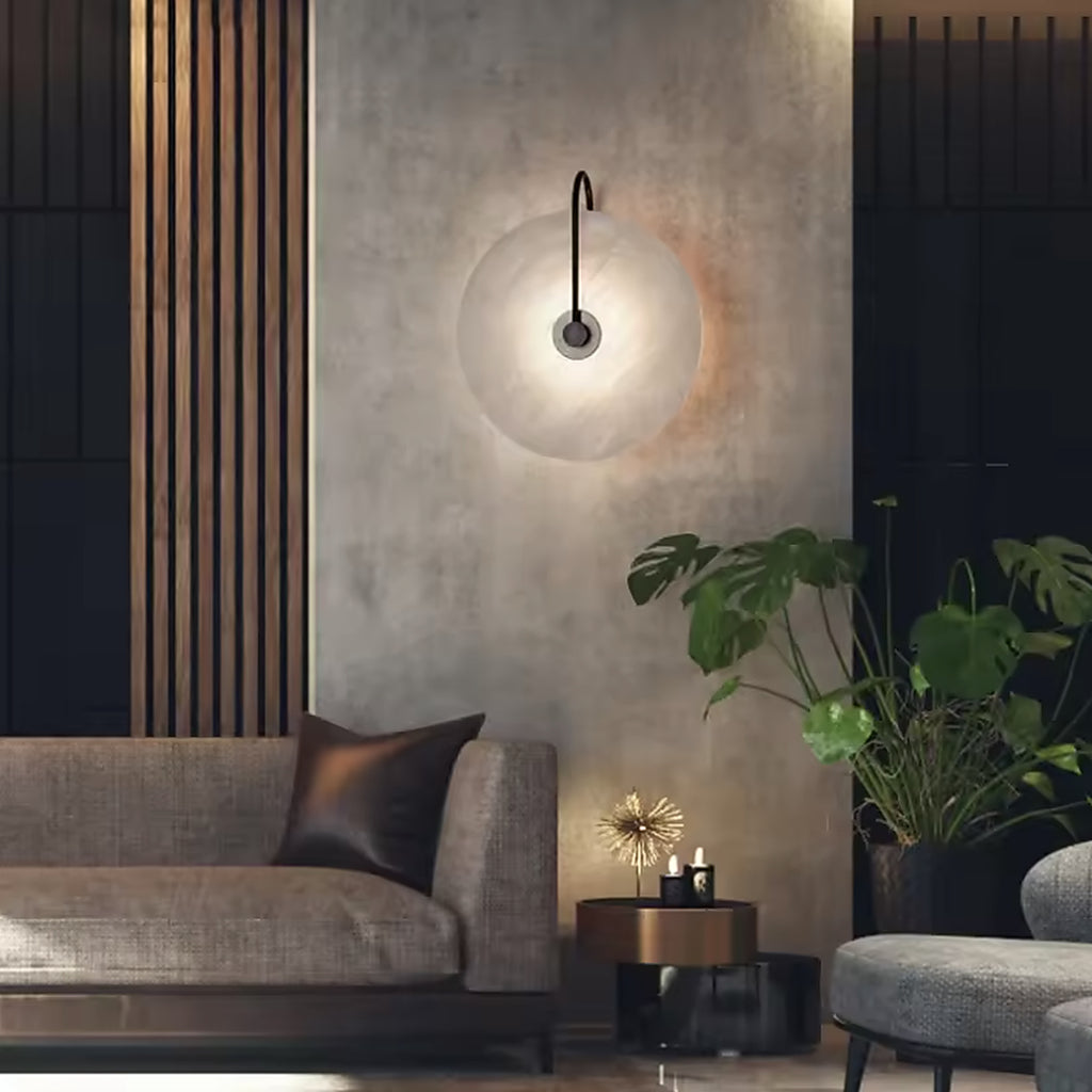 Alabaster disc wall sconce above a sofa in a modern living room