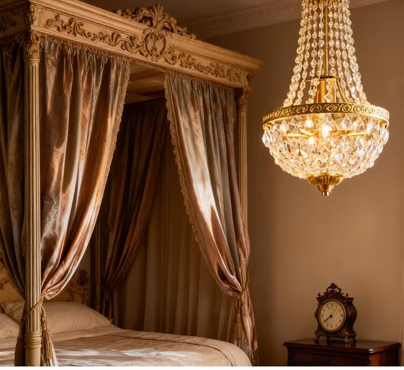 Antique crystal chandelier lit beside a carved four poster bed with silk drapes Image