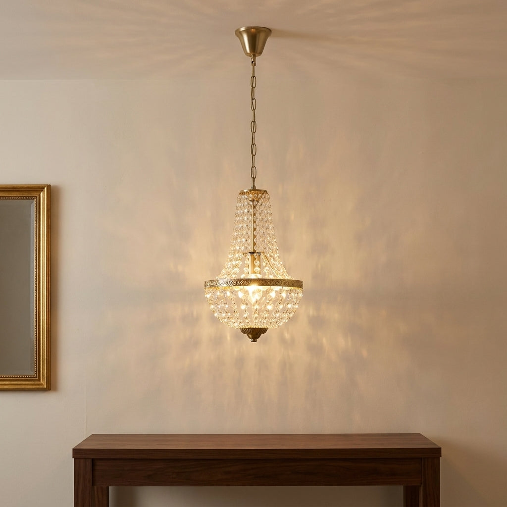 Antique crystal chandelier lit at night above a walnut console, crystal reflections on the wall Image