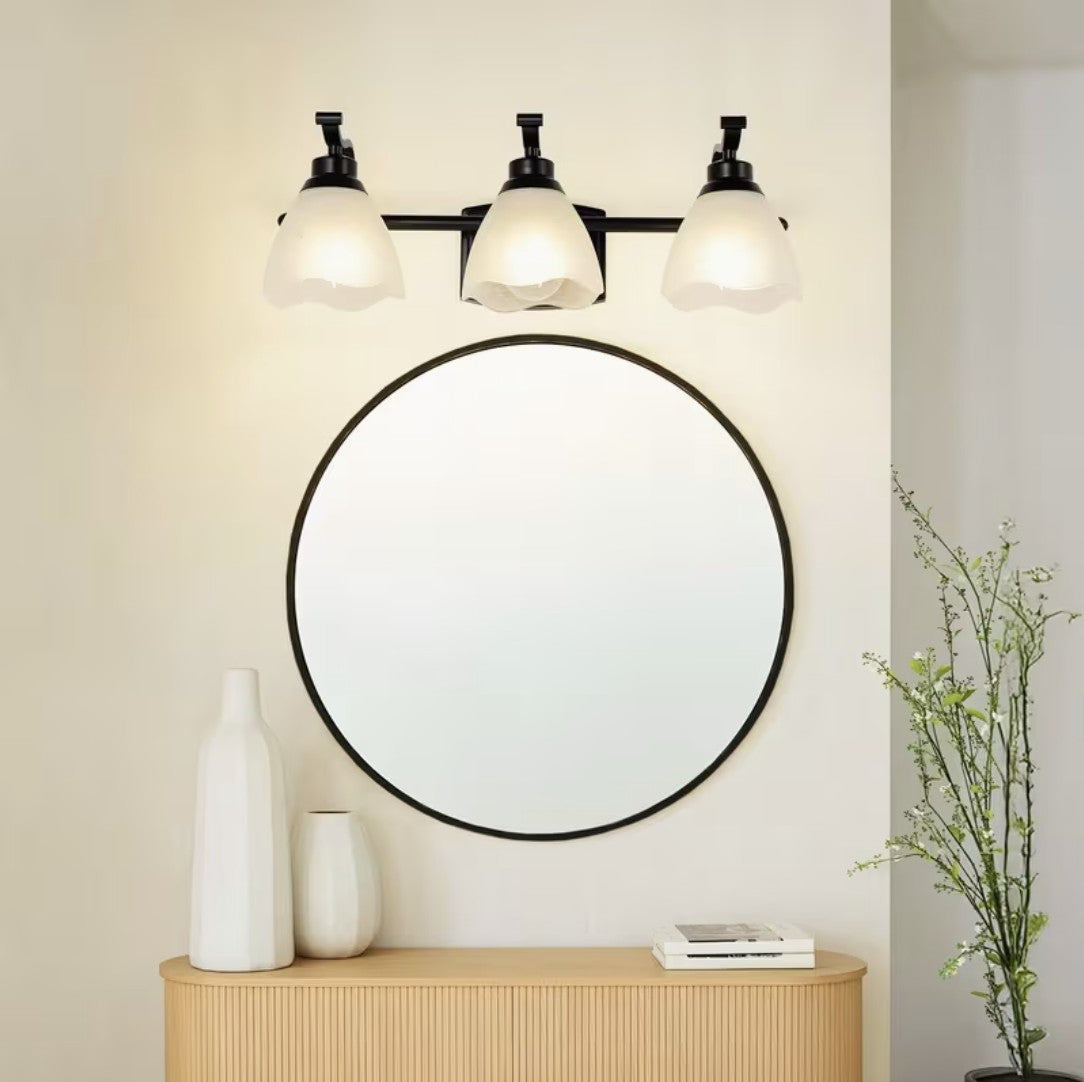 Bathroom vanity light above a round mirror in an entryway
