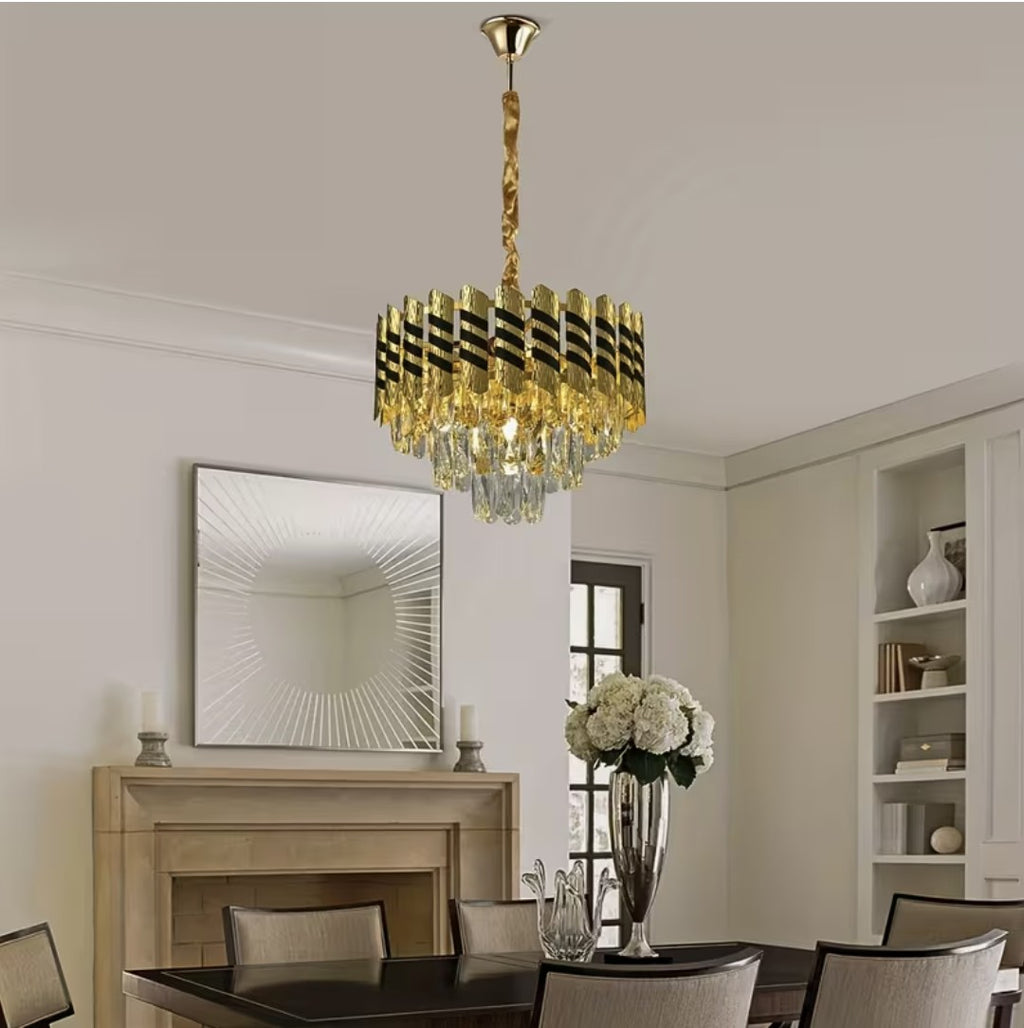 Black and gold crystal chandelier over a dining table near a fireplace