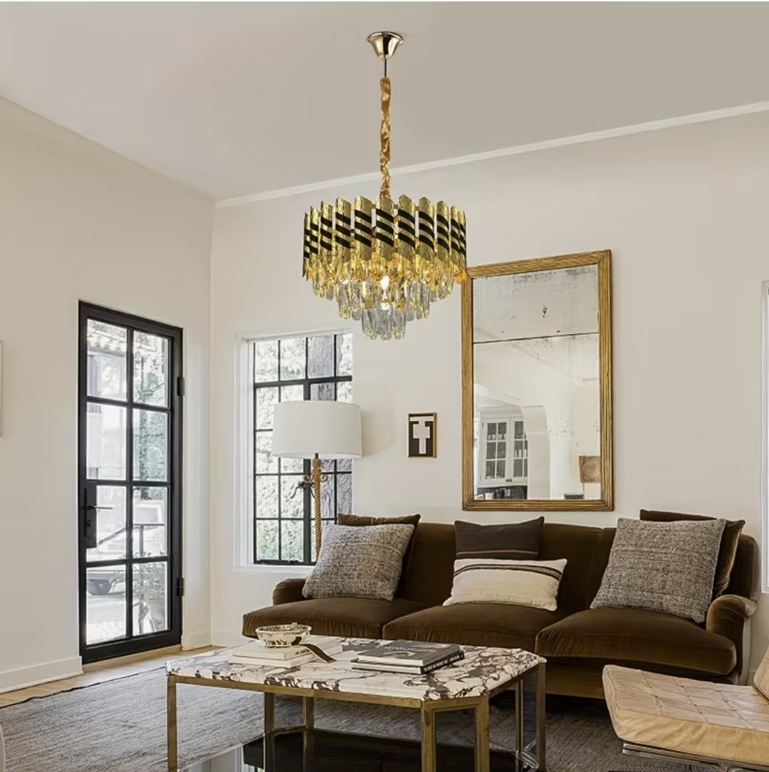 Black and gold crystal chandelier above a brown velvet sofa