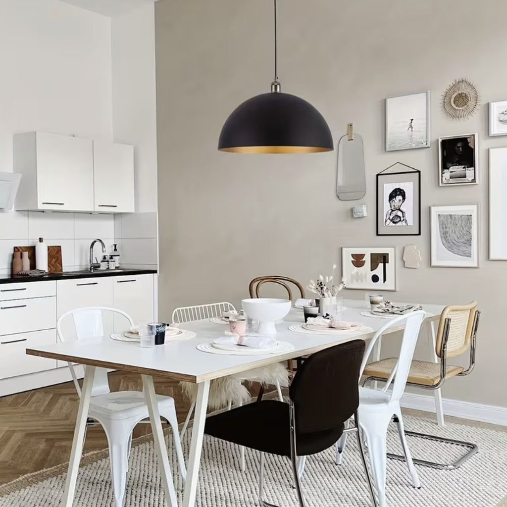 Black and gold dome pendant light over a dining table
