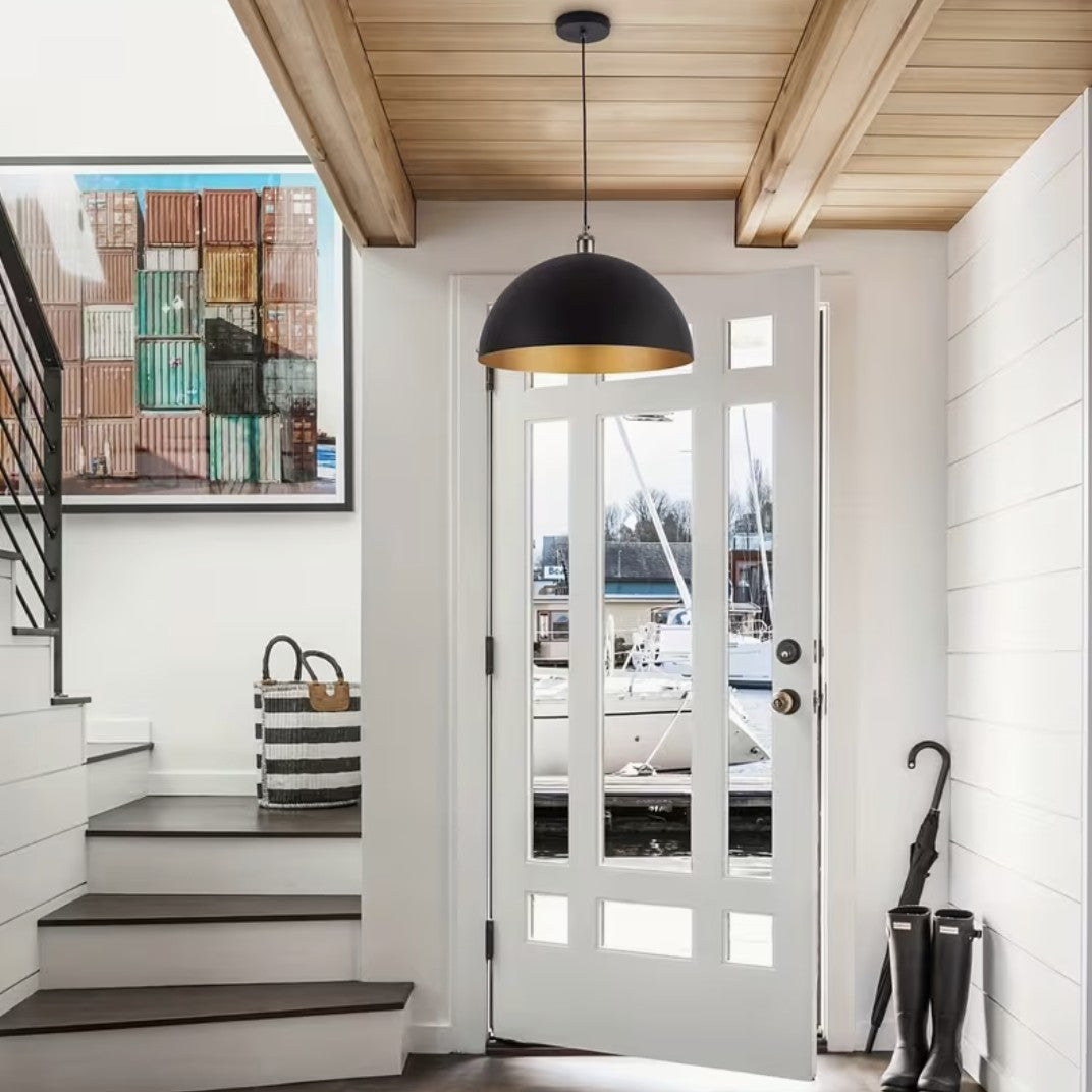 Black and gold dome pendant light above an entryway door
