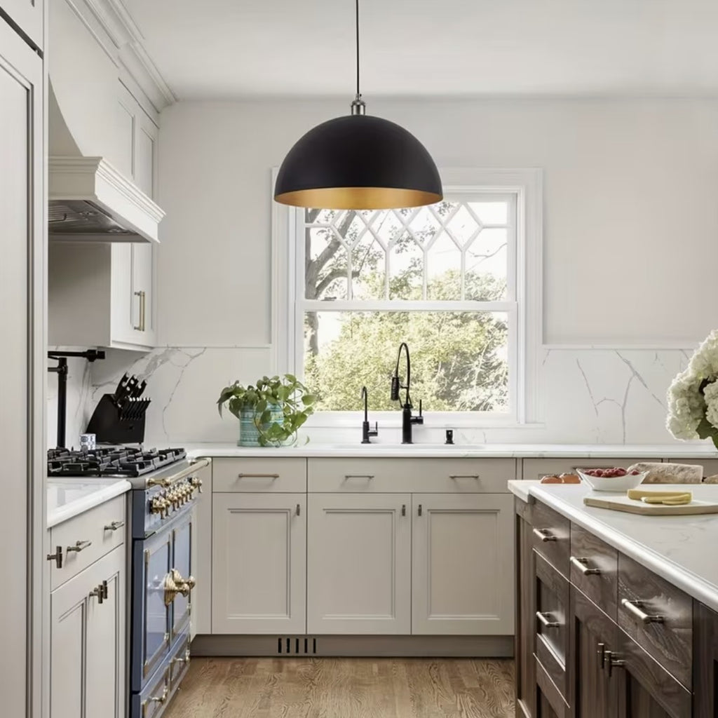 Black and gold dome pendant light above a kitchen sink