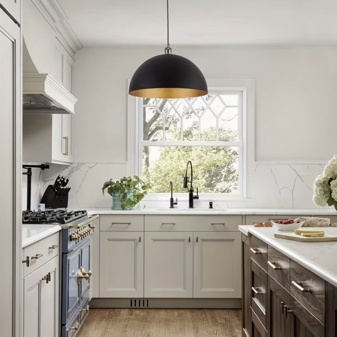 Black and gold dome pendant light above a kitchen sink