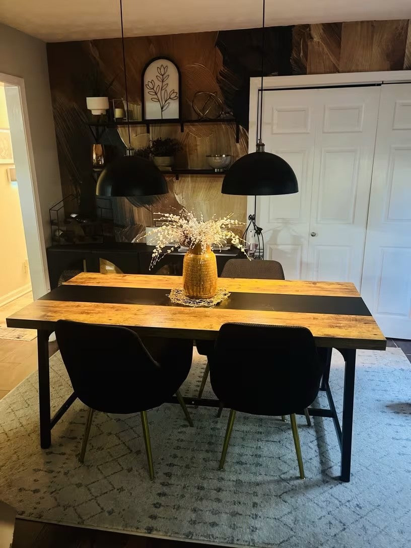 Two black and gold dome pendant lights over a wooden dining table at home