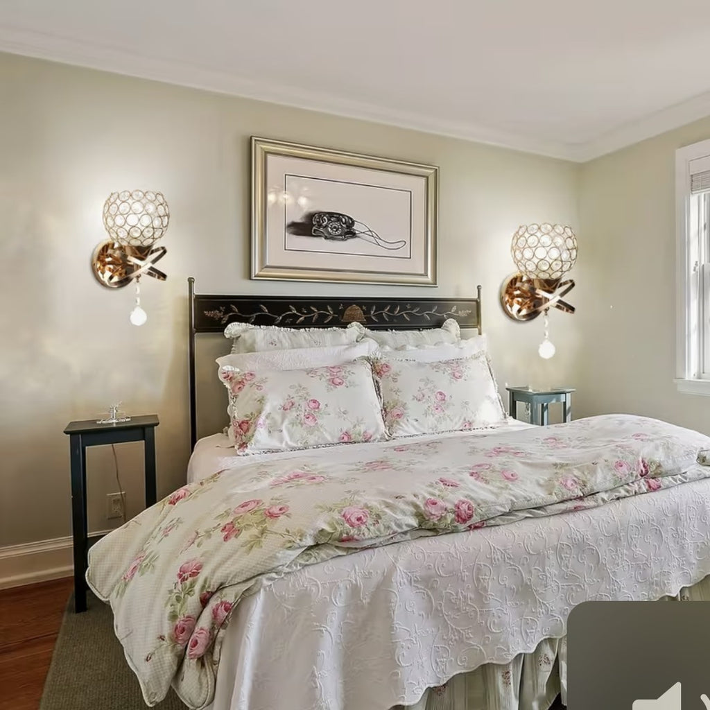 Gold crystal globe wall sconces either side of a bed