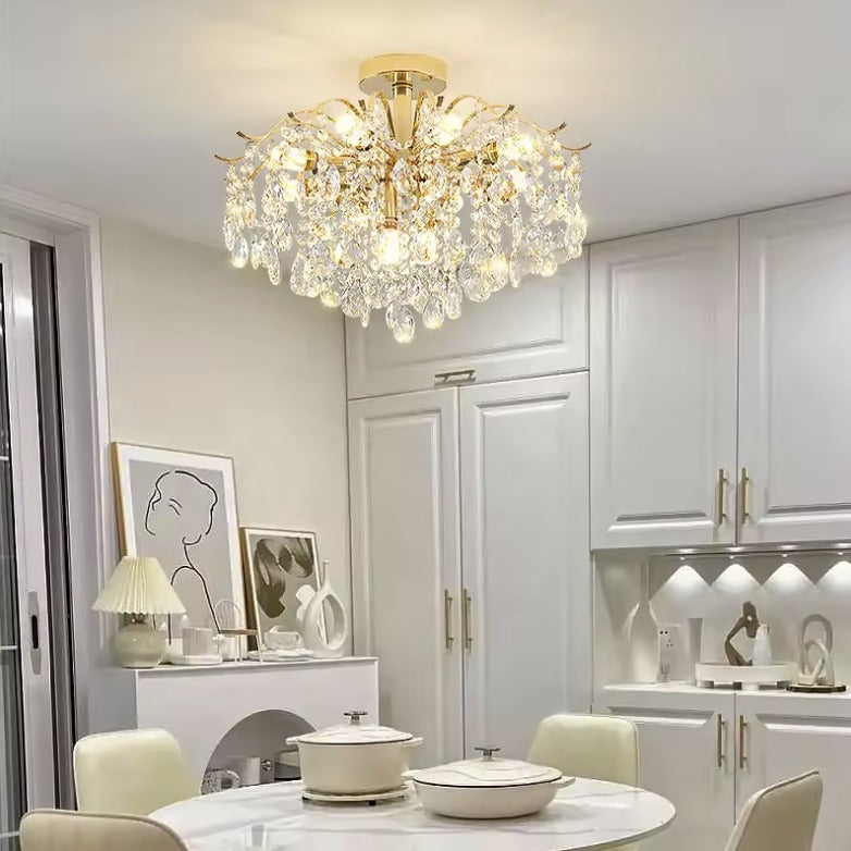 Gold crystal flush mount ceiling light above a round table in a white dining room