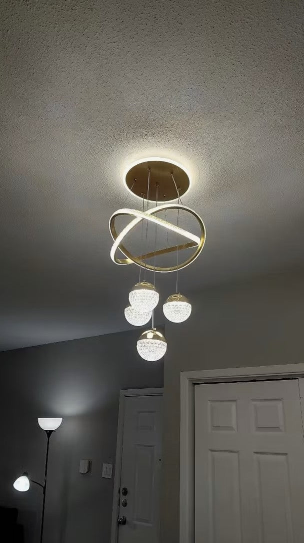 Customer photo, gold globe chandelier lit in an entryway