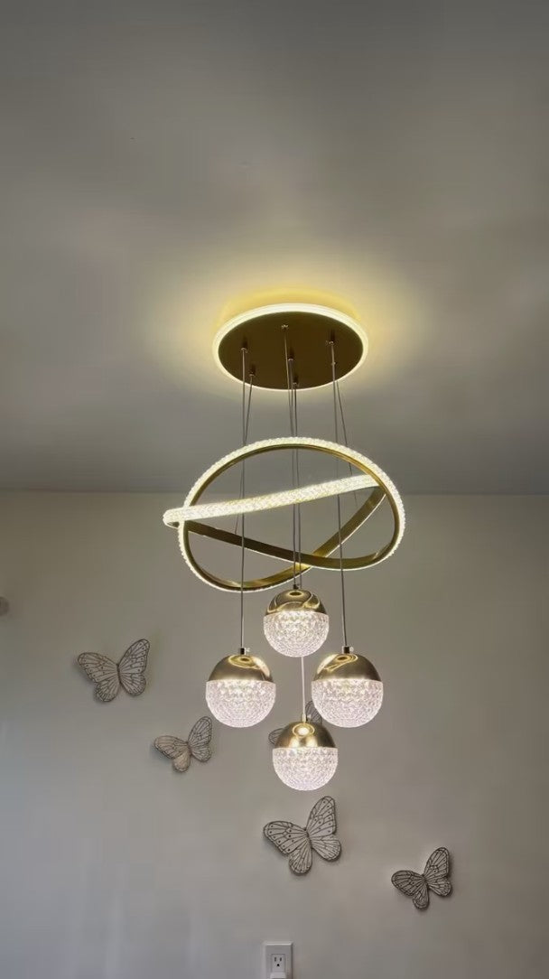 Customer photo, gold globe chandelier lit above a hallway