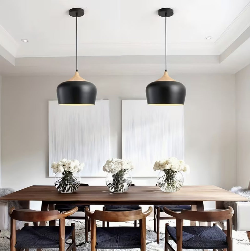 Two black kitchen island pendant lights above a dining table
