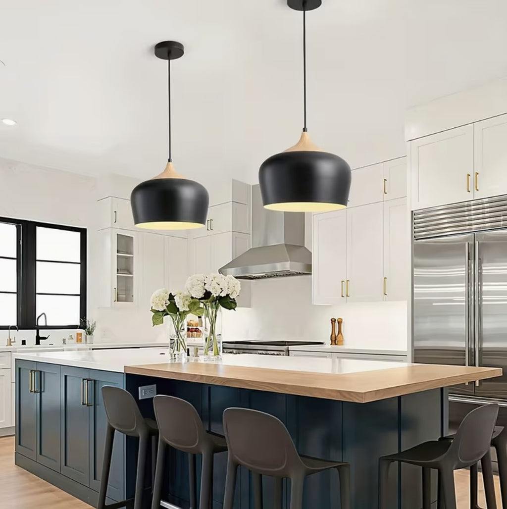 Two black kitchen island pendant lights above a blue island