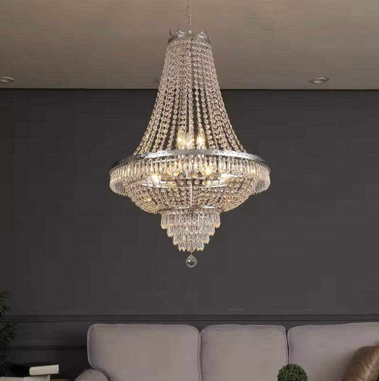 Large empire crystal chandelier in silver lit in a grey living room