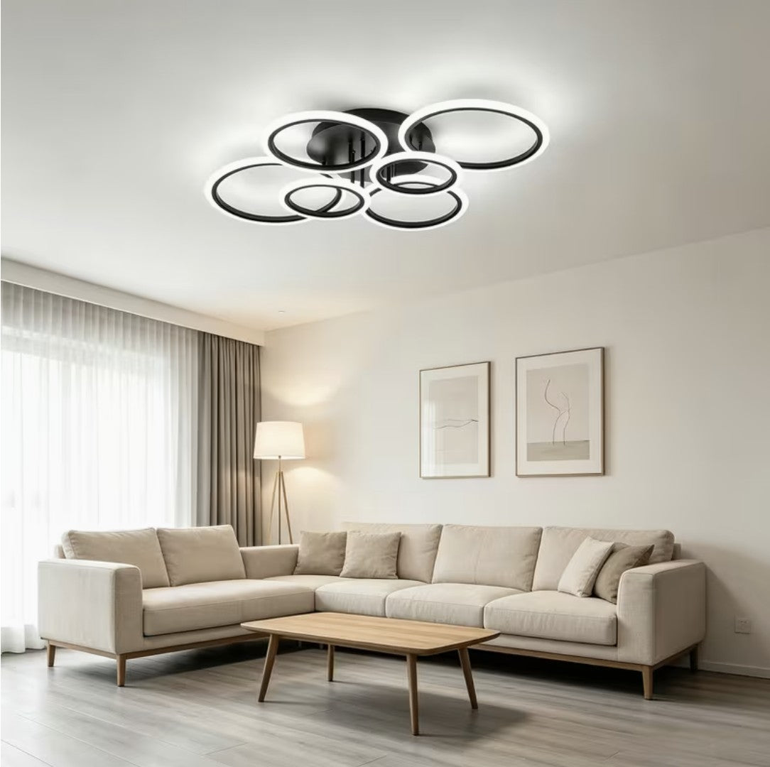 Black LED ring ceiling light above a corner sofa in a living room