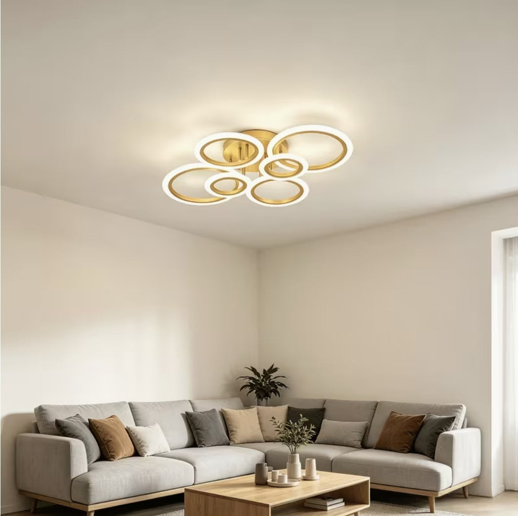 Gold LED ring ceiling light above a corner sofa