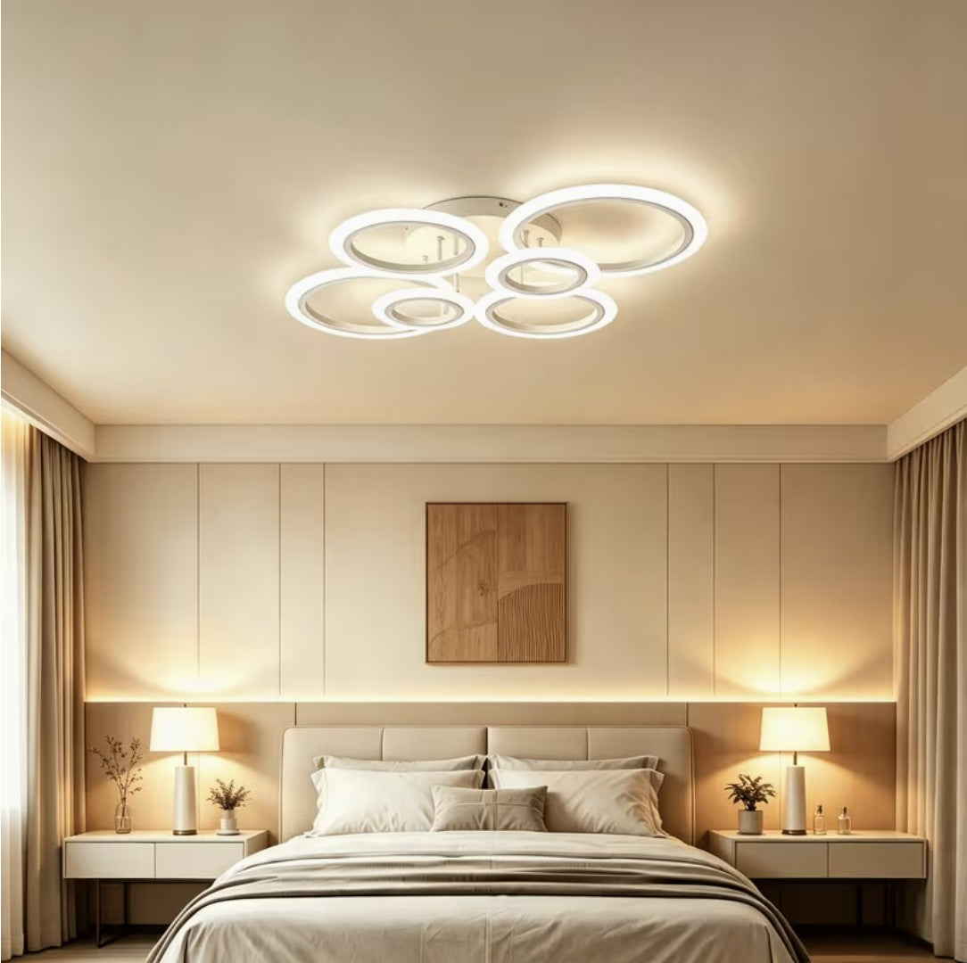 White LED ring ceiling light above a bed between two lamps