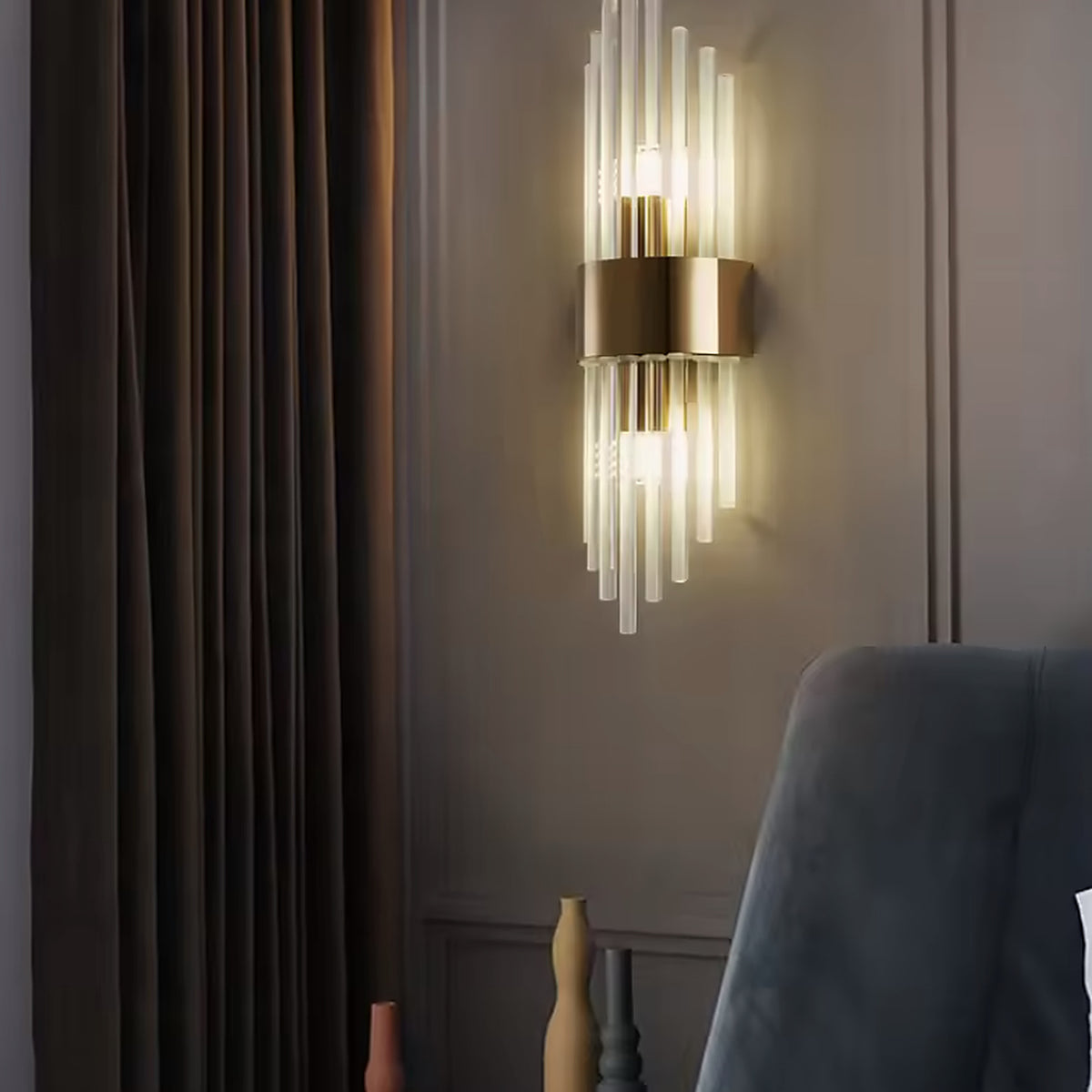Gold linear glass rod wall sconce beside a bed at night
