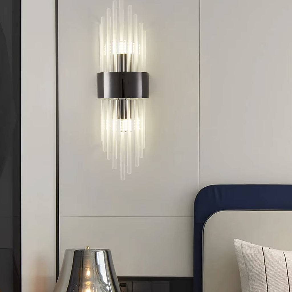 Black linear glass rod wall sconce beside a bed