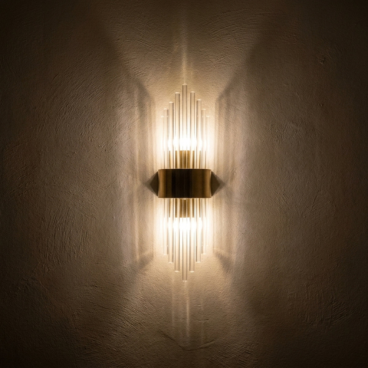 The sconce at night throwing two cones of light up and down the wall