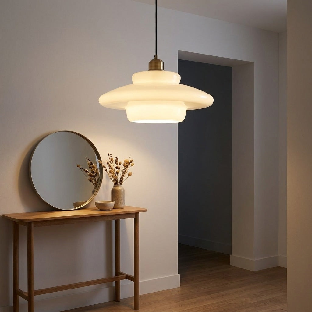 Wide saucer milk glass pendant light lit above a console in an entrance hall Image