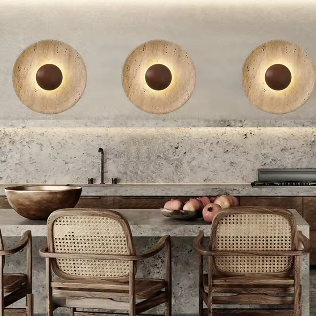 Three travertine wall sconces above a stone kitchen counter