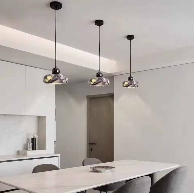Three marble mini pendant lights above a dining table