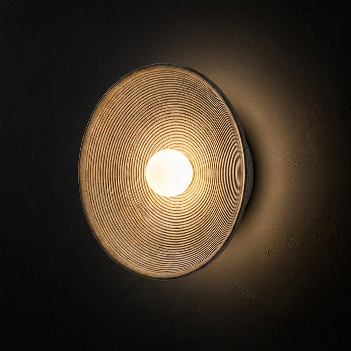 Nordic round wall sconce seen at an angle, showing the depth of the ribbed cone Image