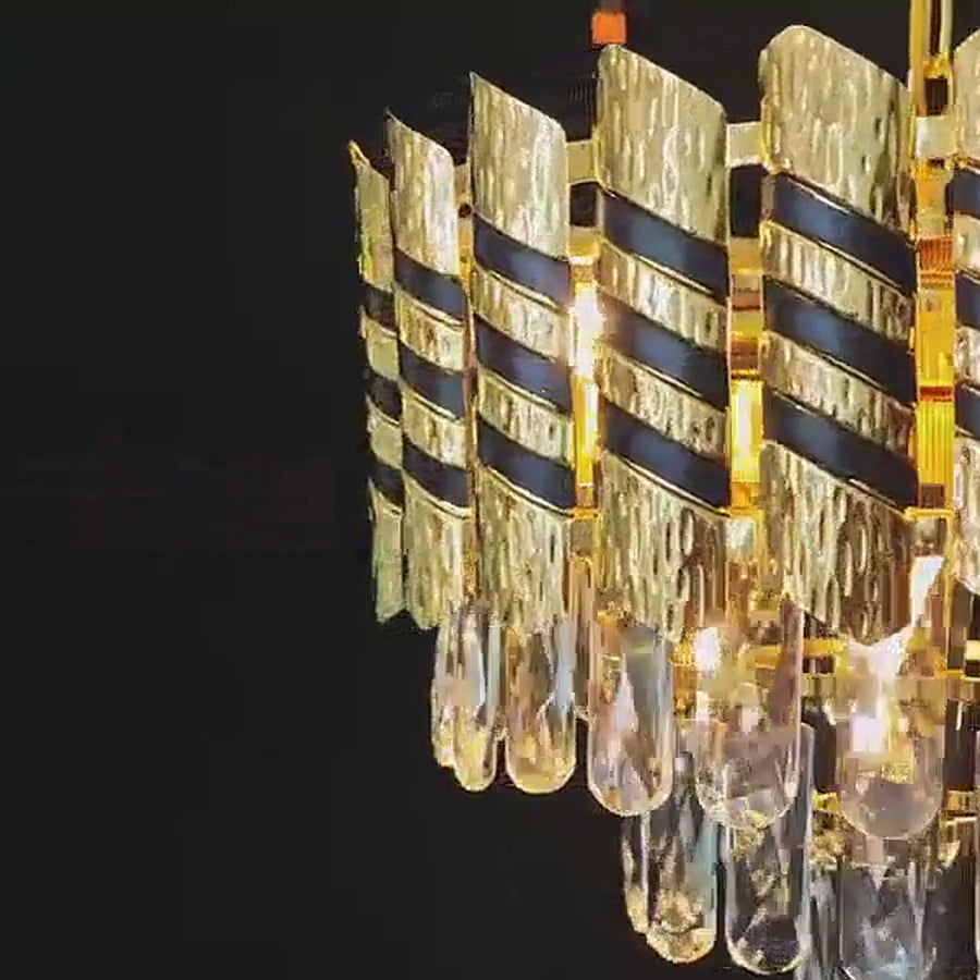 Black and gold crystal chandelier filmed lit