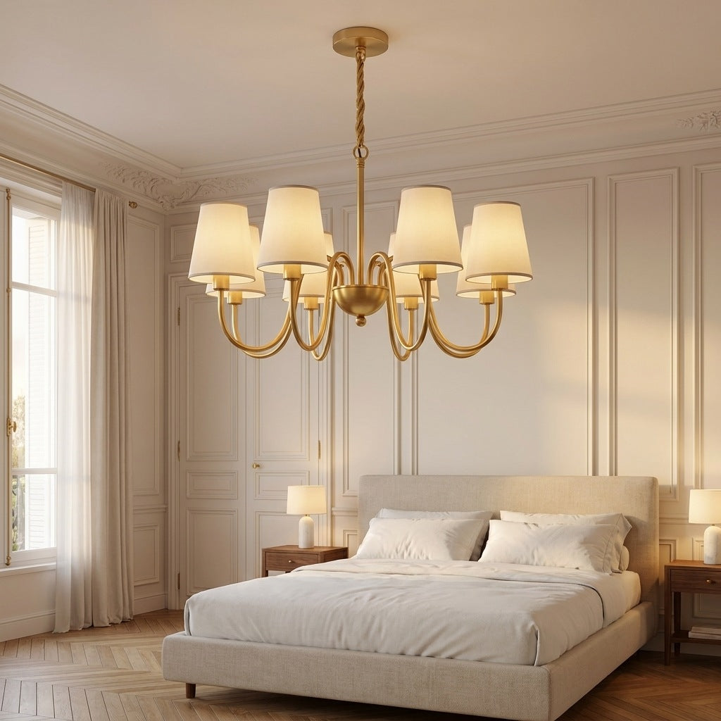 Vintage brass chandelier lit in a Haussmann bedroom above a linen bed