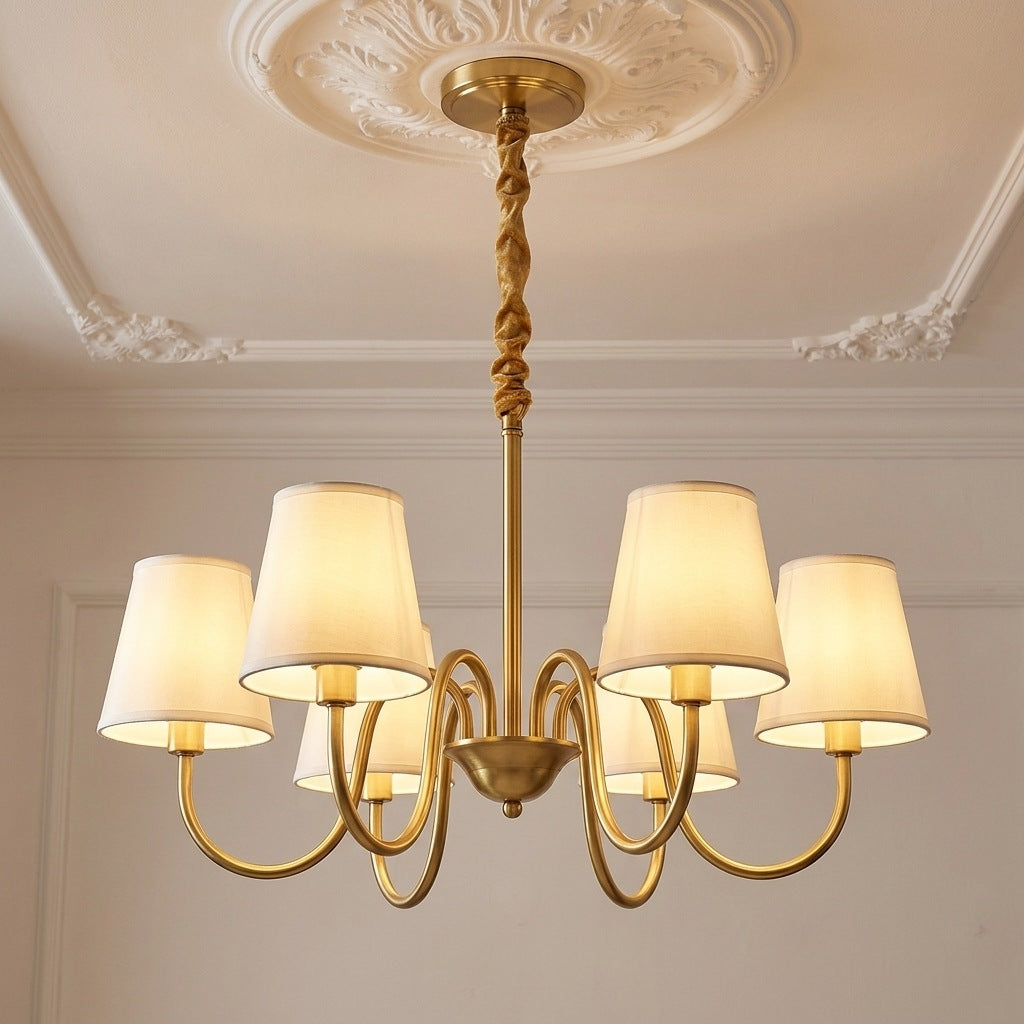 Vintage brass chandelier with 6 ivory fabric shades lit on a moulded ceiling, 28.7 inches across